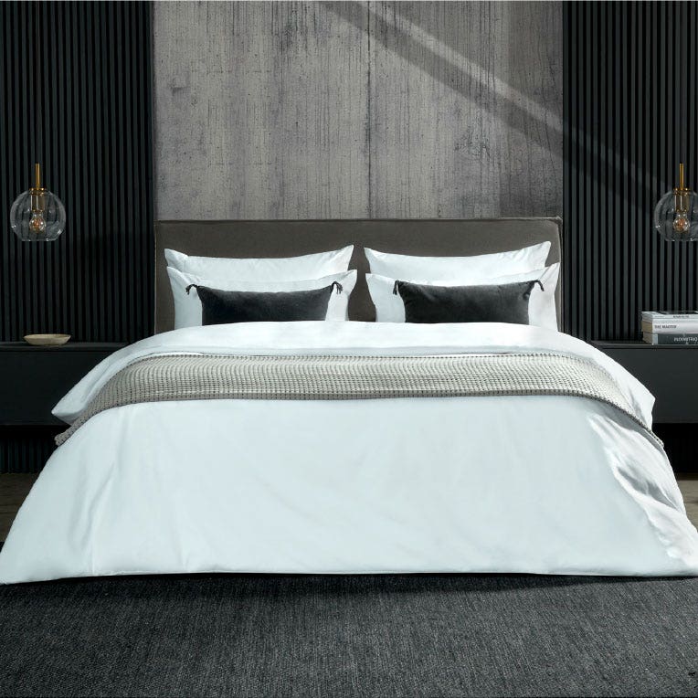 Habitación de hotel con ropa de cama en tonos grises y negros