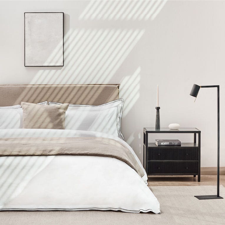 Dormitorio iluminado por el sol con ropa de cama beige
